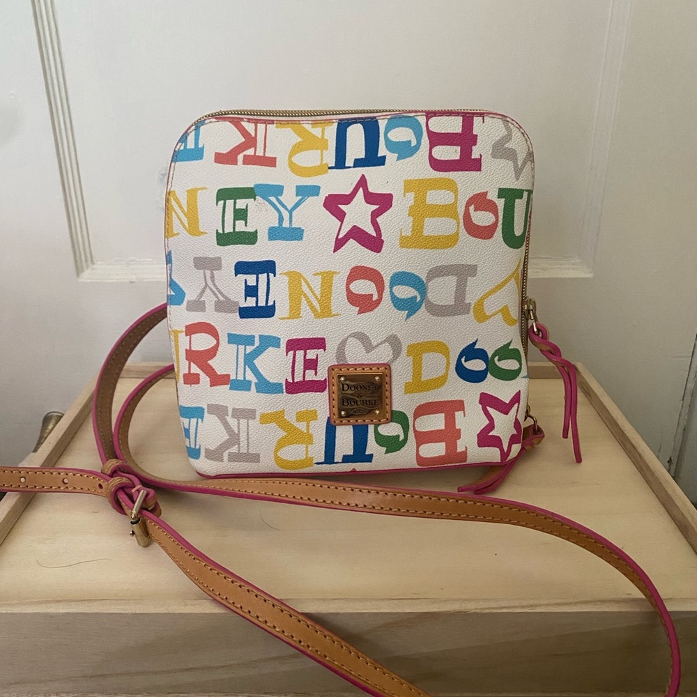 Dooney and Bourke cross body purse with rainbow lettering and pink detailing